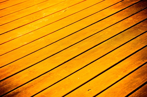 Golden-hued wooden planks arranged parallel to each other, with visible grain and texture.