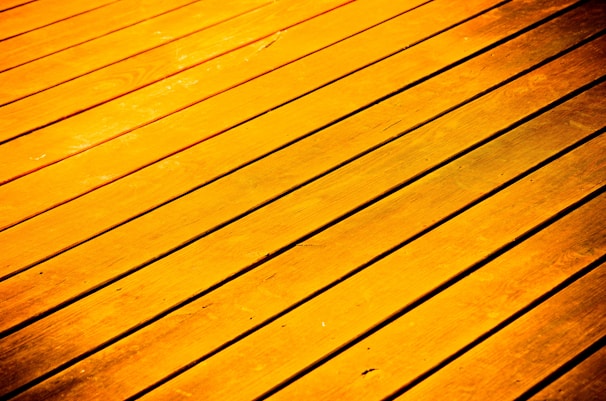 Golden-hued wooden planks arranged parallel to each other, with visible grain and texture.