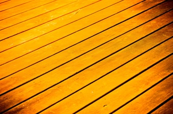 Golden-hued wooden planks arranged parallel to each other, with visible grain and texture.