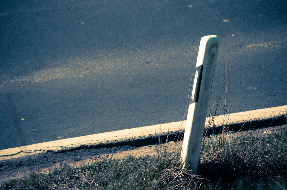 a broken street sign sitting on the side of a road