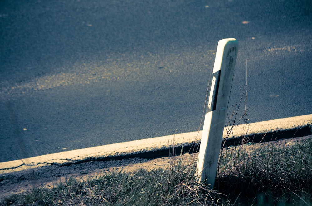 Un letrero roto de la calle sentado al costado de una carretera