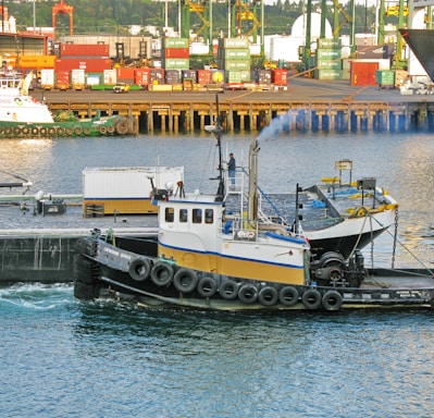 a tug boat in the water near a dock