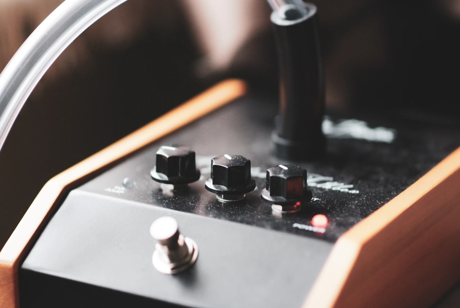 Ratline Fuzz pedal sitting in a wooden tray, three knobs and a footswitch, in stock