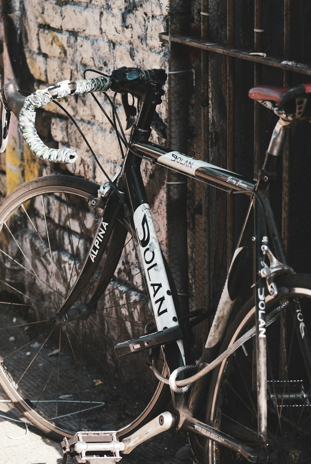 a bicycle parked next to a brick wall