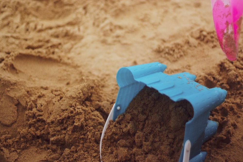 a toy beach chair and shovel in the sand