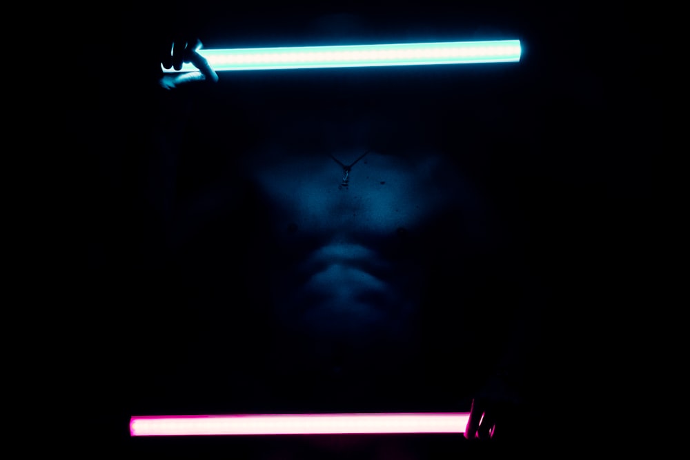 a man's face is illuminated by a neon light