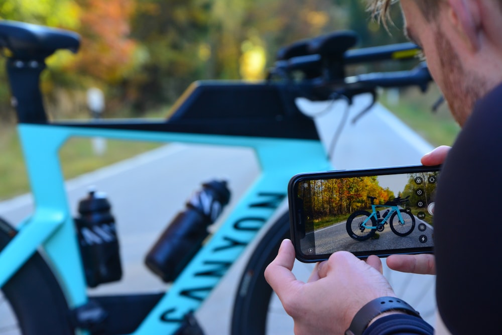 um homem tirando uma foto de uma bicicleta com seu telefone