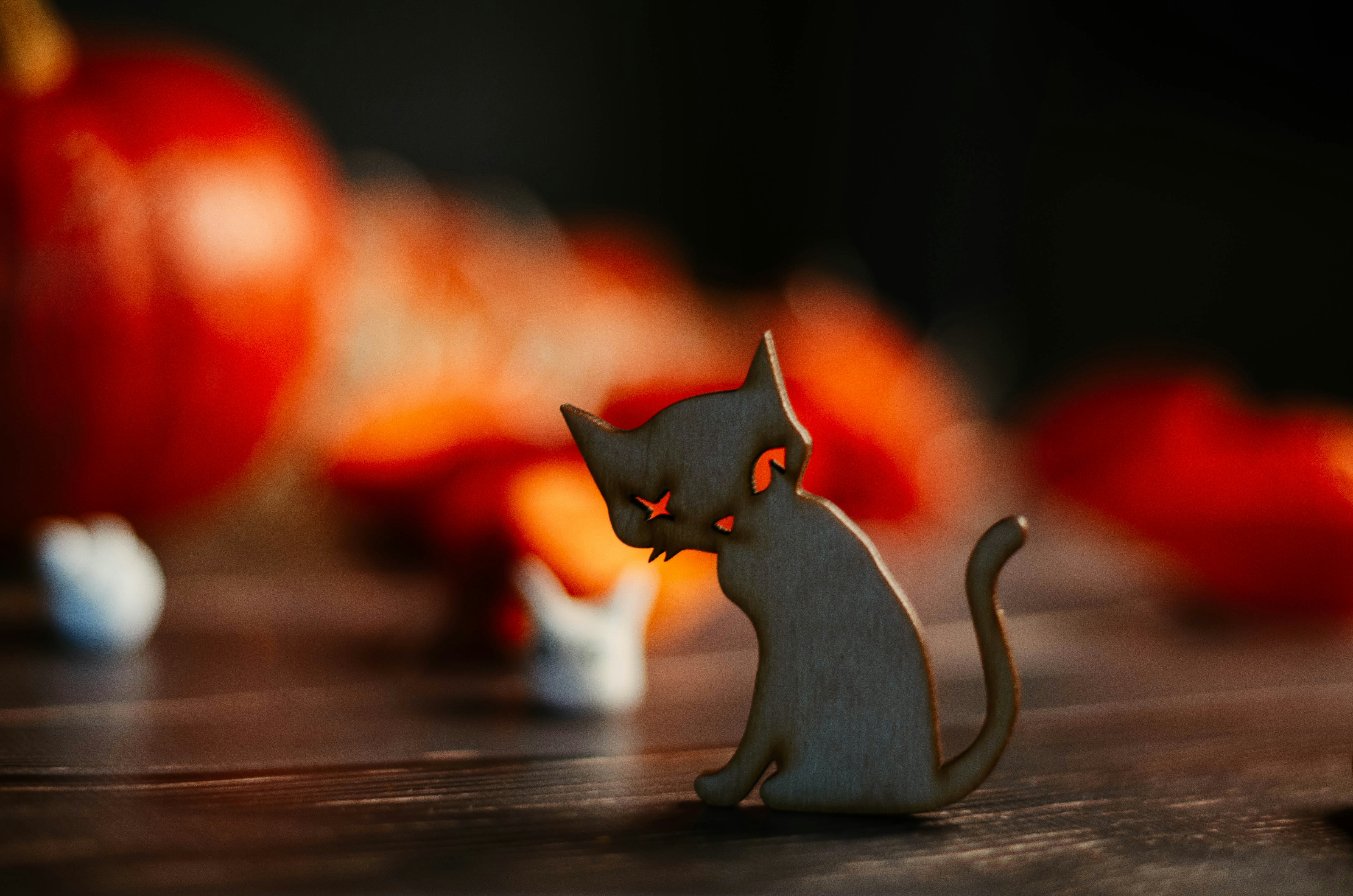 a cat figurine sitting on top of a wooden table