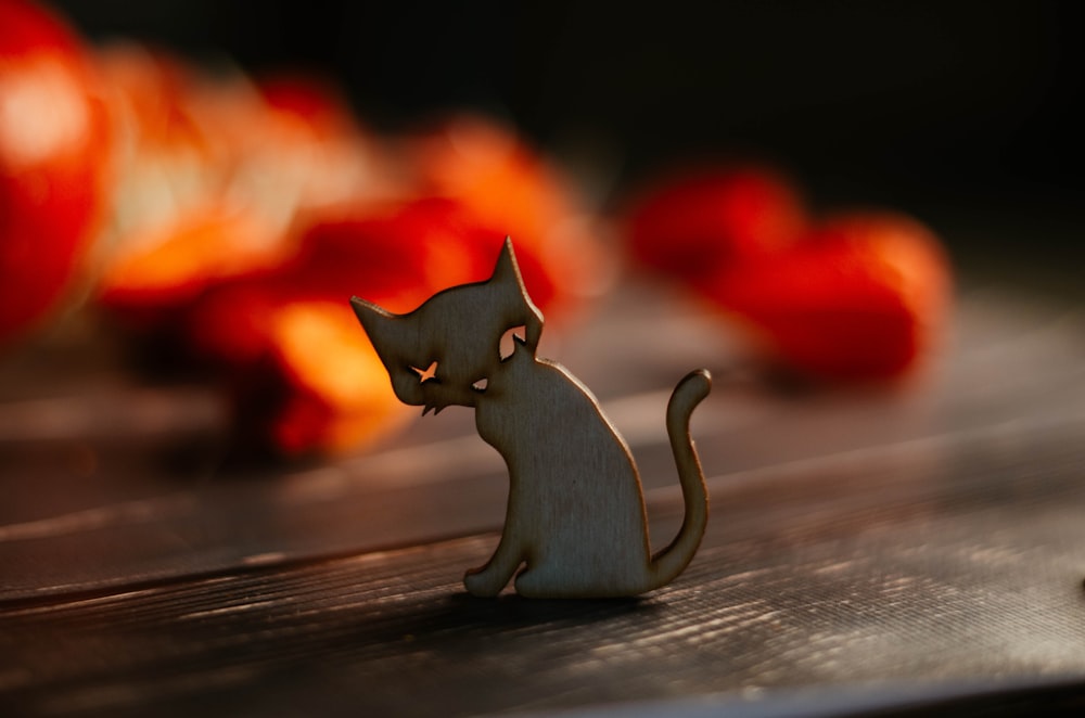 a cat figurine sitting on top of a wooden table