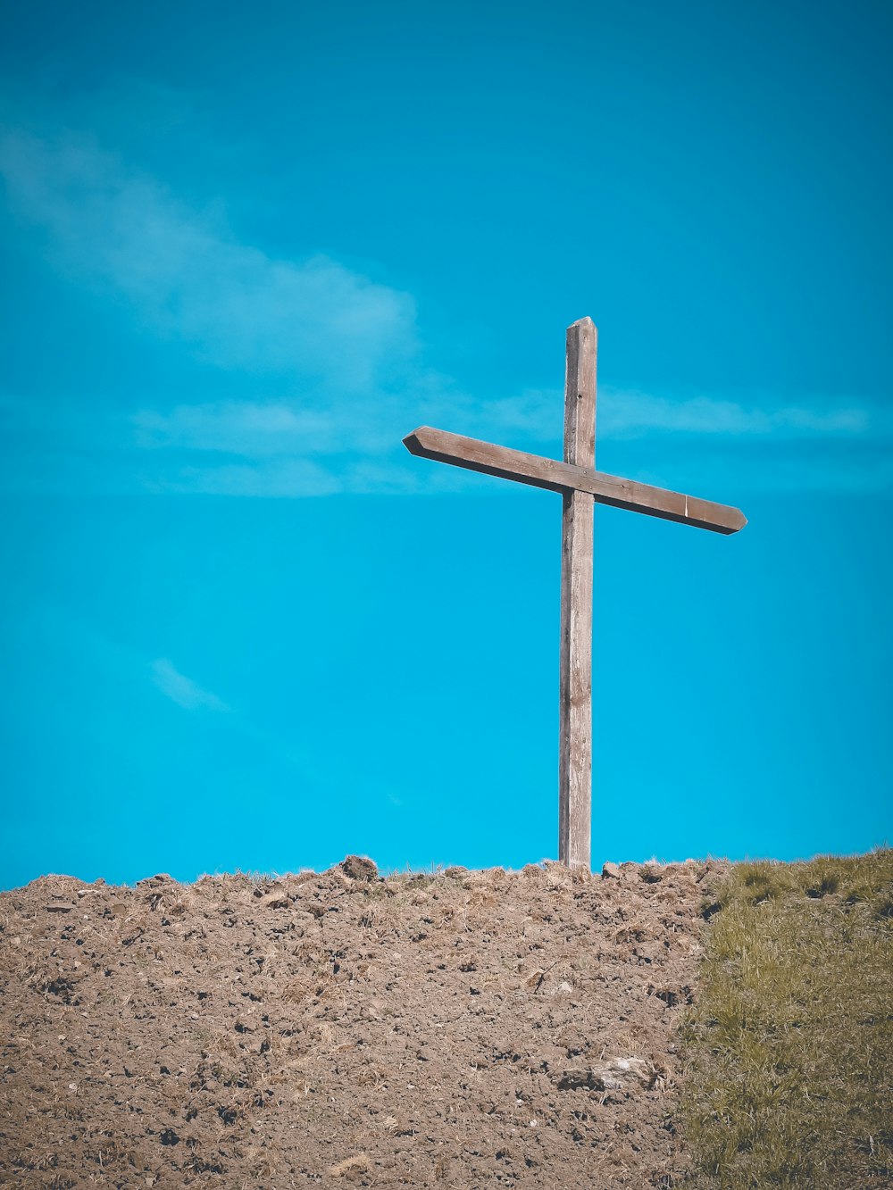 a wooden cross sitting on top of a hill
