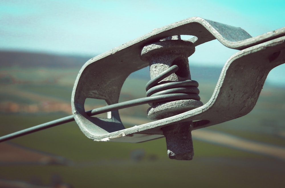 a close up of a metal object with a sky background