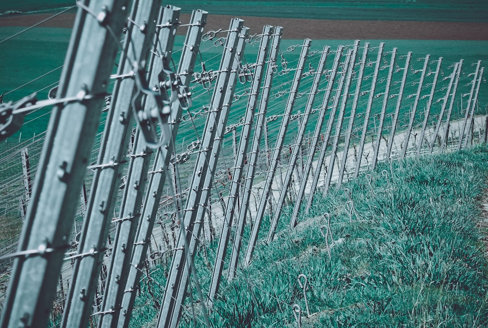 a row of barbed wire fences next to a grassy field