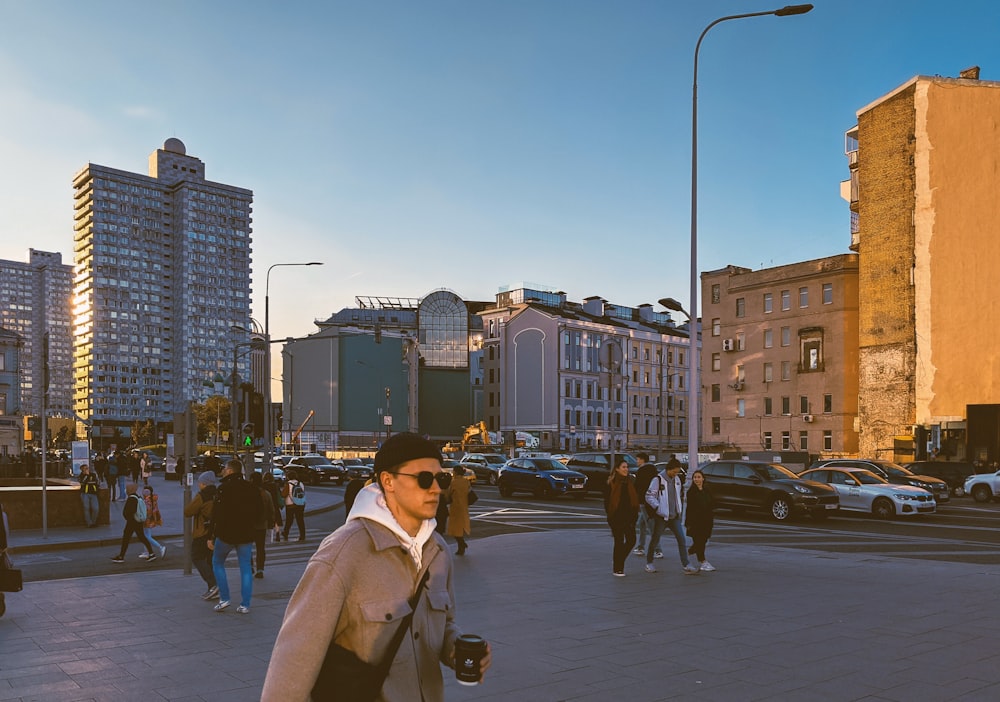 a man walking down a street next to tall buildings