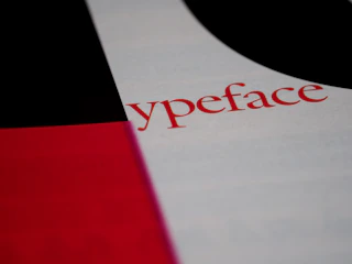 A high-contrast editorial layout featuring deep red and vintage cream blocks with bold sans-serif typography.