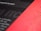 A close-up view of a printed page with a blurred mix of black and red sections. The text 'for the design' is partially visible and the overall appearance is abstract and artistic.