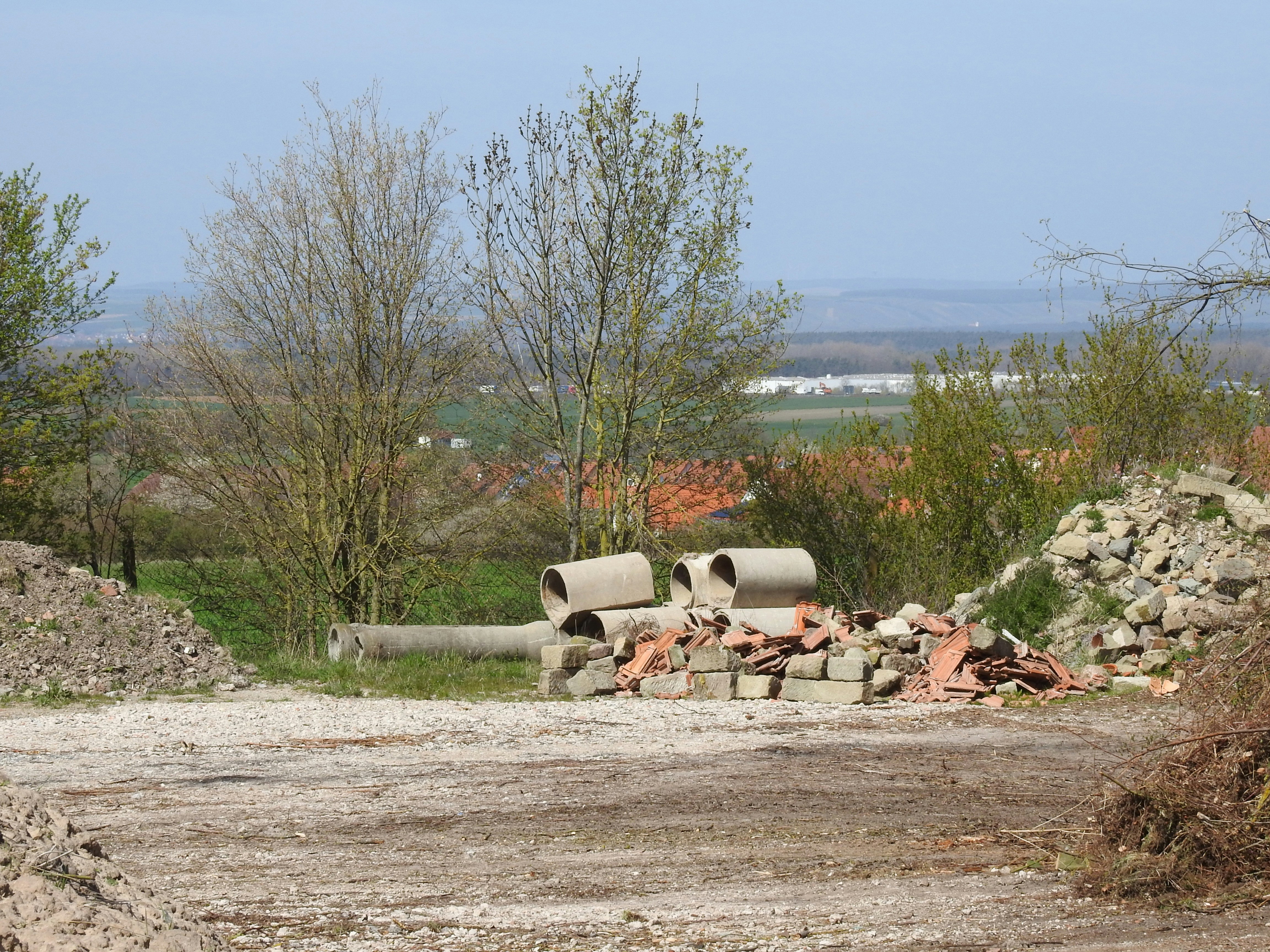 a pile of pipes sitting on top of a dirt field