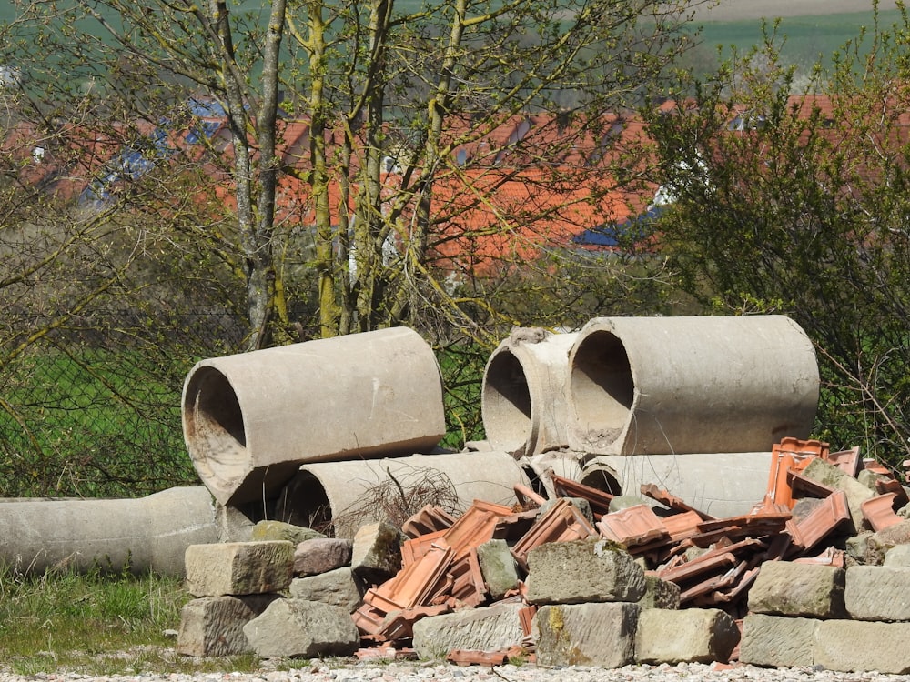 a pile of cement pipes sitting on top of a pile of rocks
