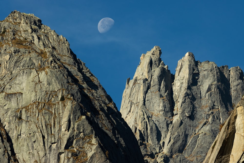 a mountain with a half moon in the sky