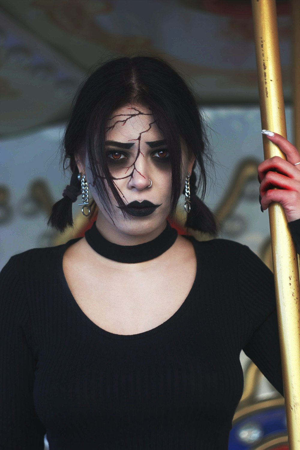 Una mujer con maquillaje negro sosteniendo un poste