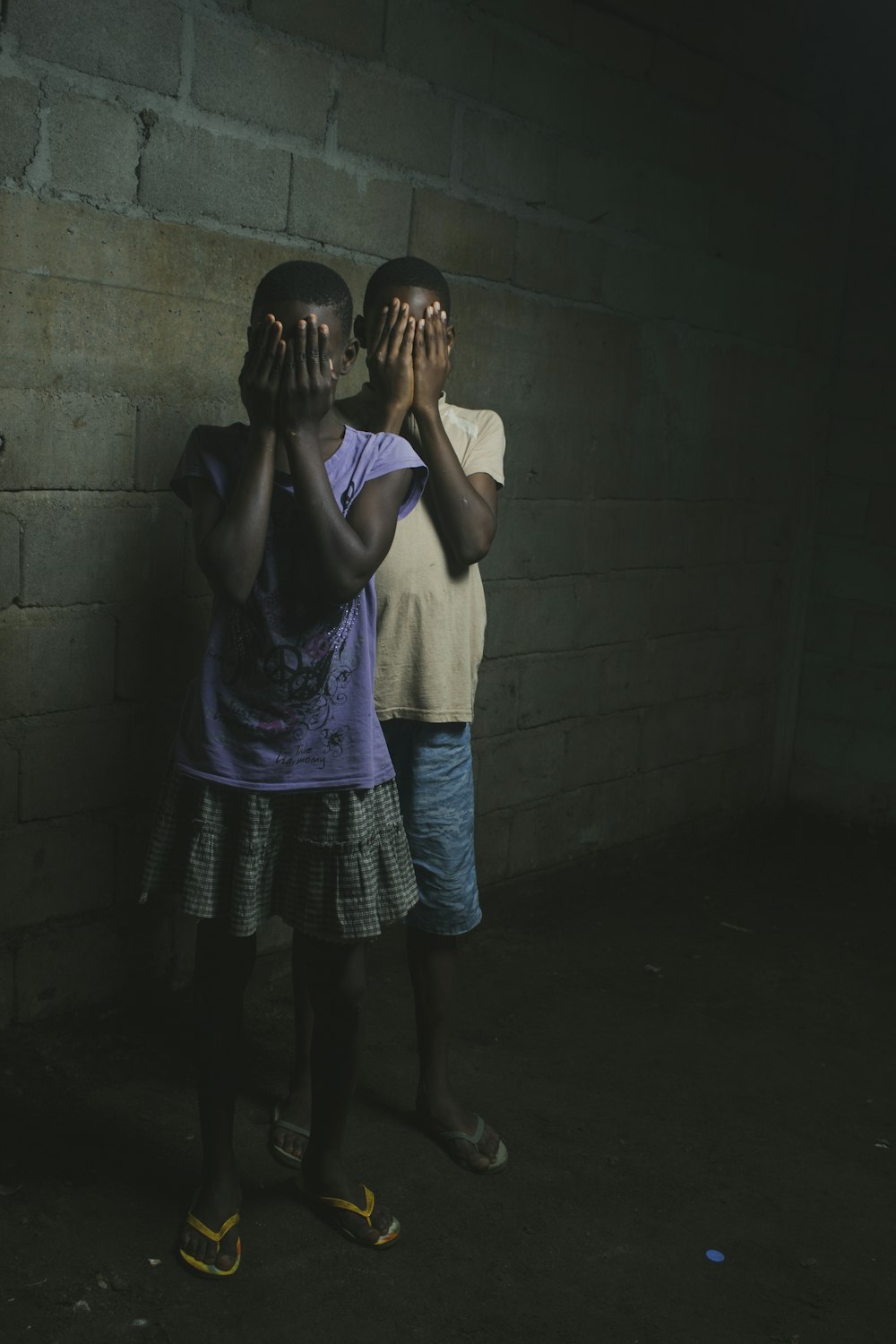 two children covering their faces with their hands