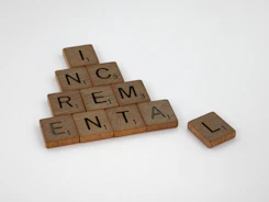 a scrabbled wooden block with the words incremential and rental