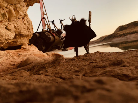 A sleek, modern exoskeleton device in use during an outdoor hike at sunset.