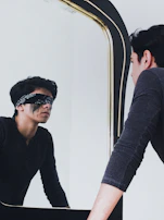 Blacka G in a tense moment, staring into a mirror with conflicted emotions.