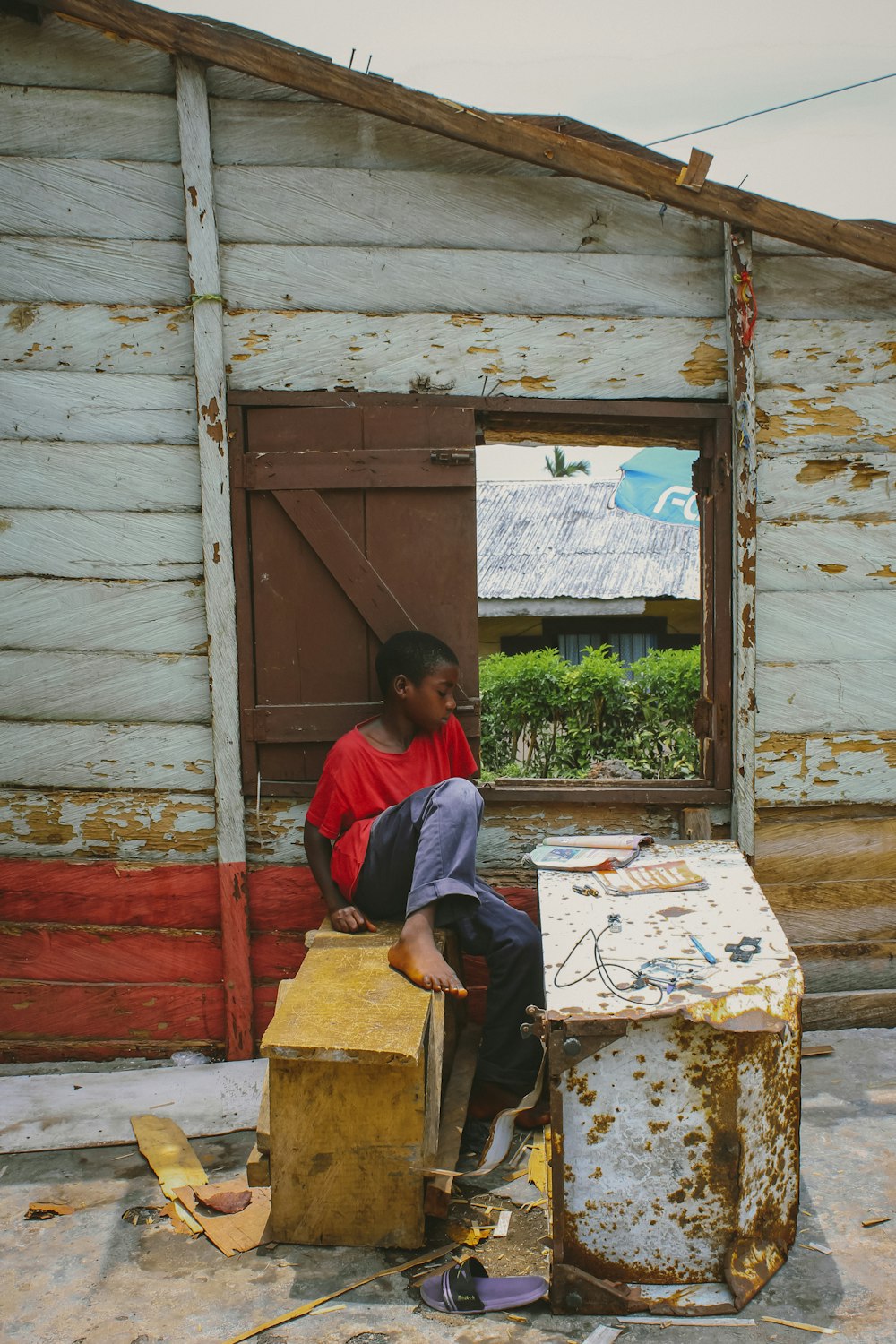 a boy sitting on a box in front of a building