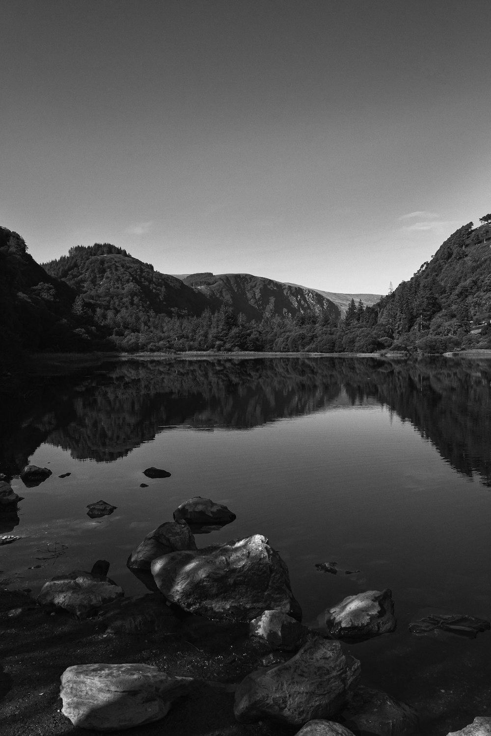 a black and white photo of a mountain lake