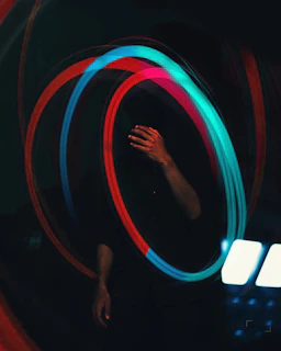 a blurry photo of a person's hand holding a neon hula hoop