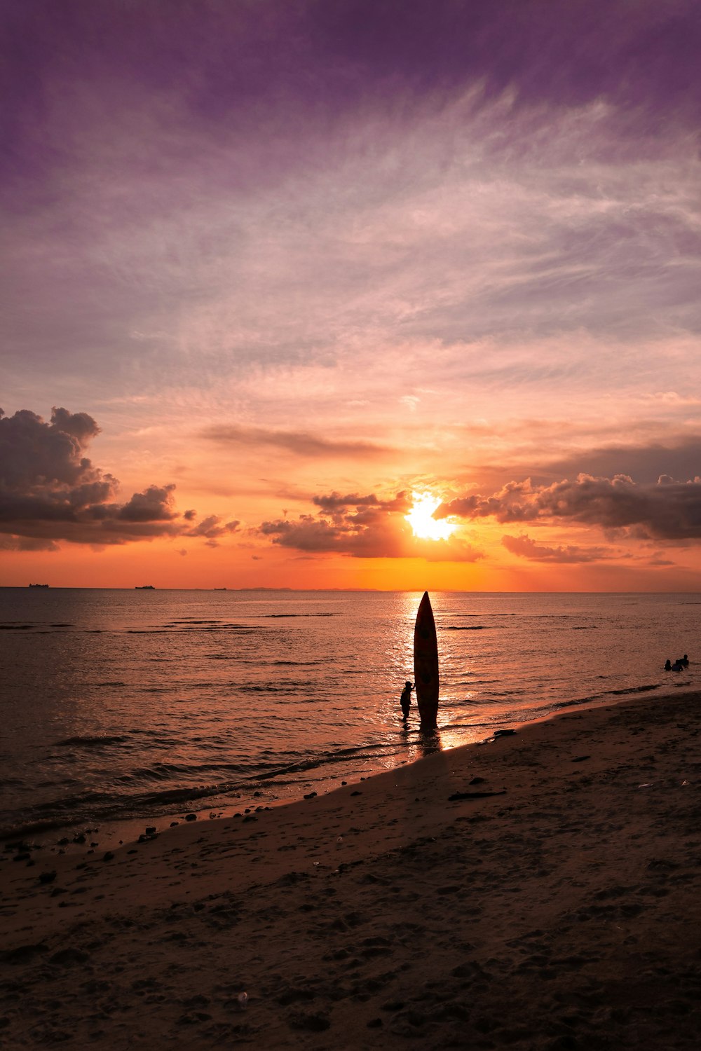 a person standing on a beach with a surfboard