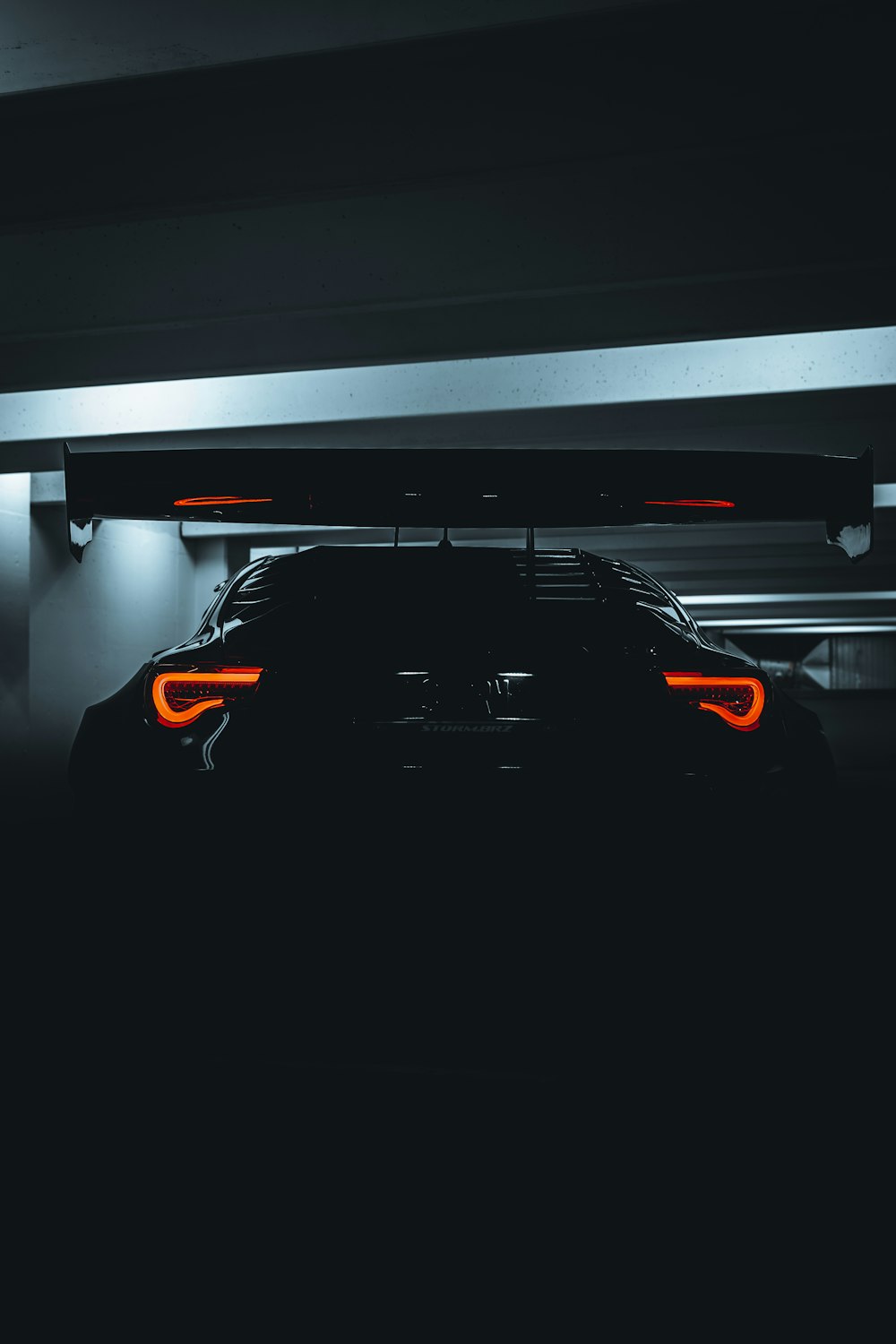 a car parked in a garage with its lights on