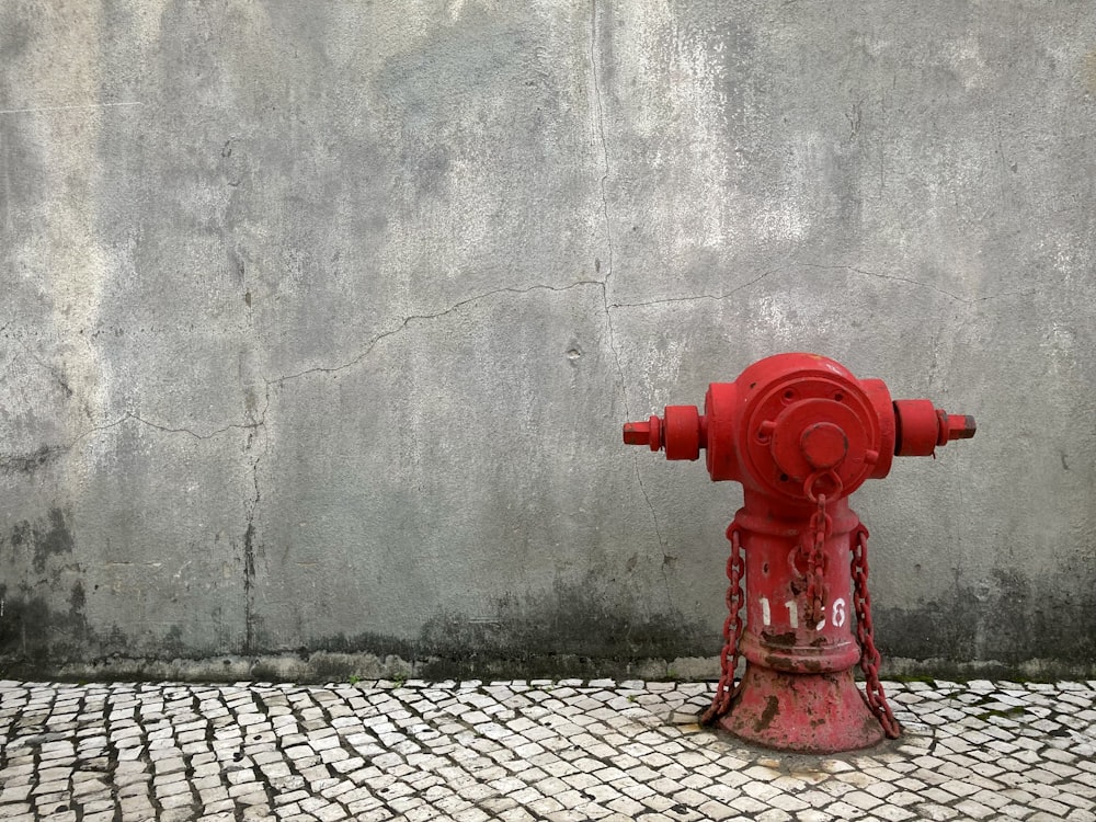 a red fire hydrant sitting on top of a sidewalk