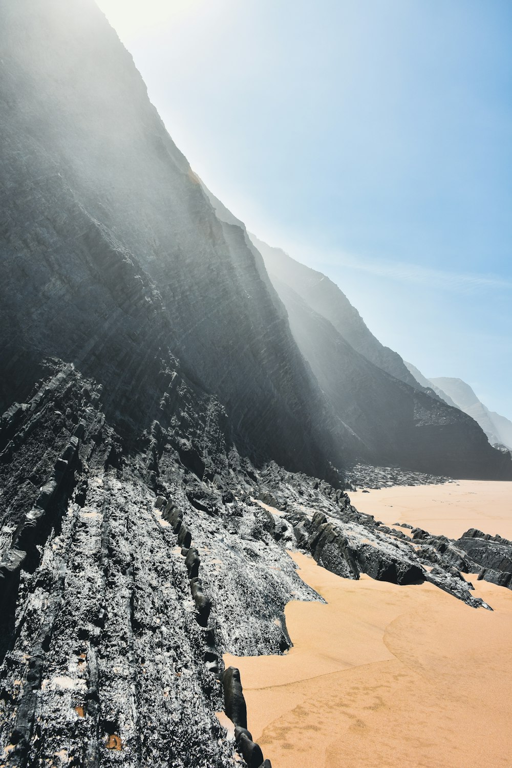 a sandy beach with a mountain in the background