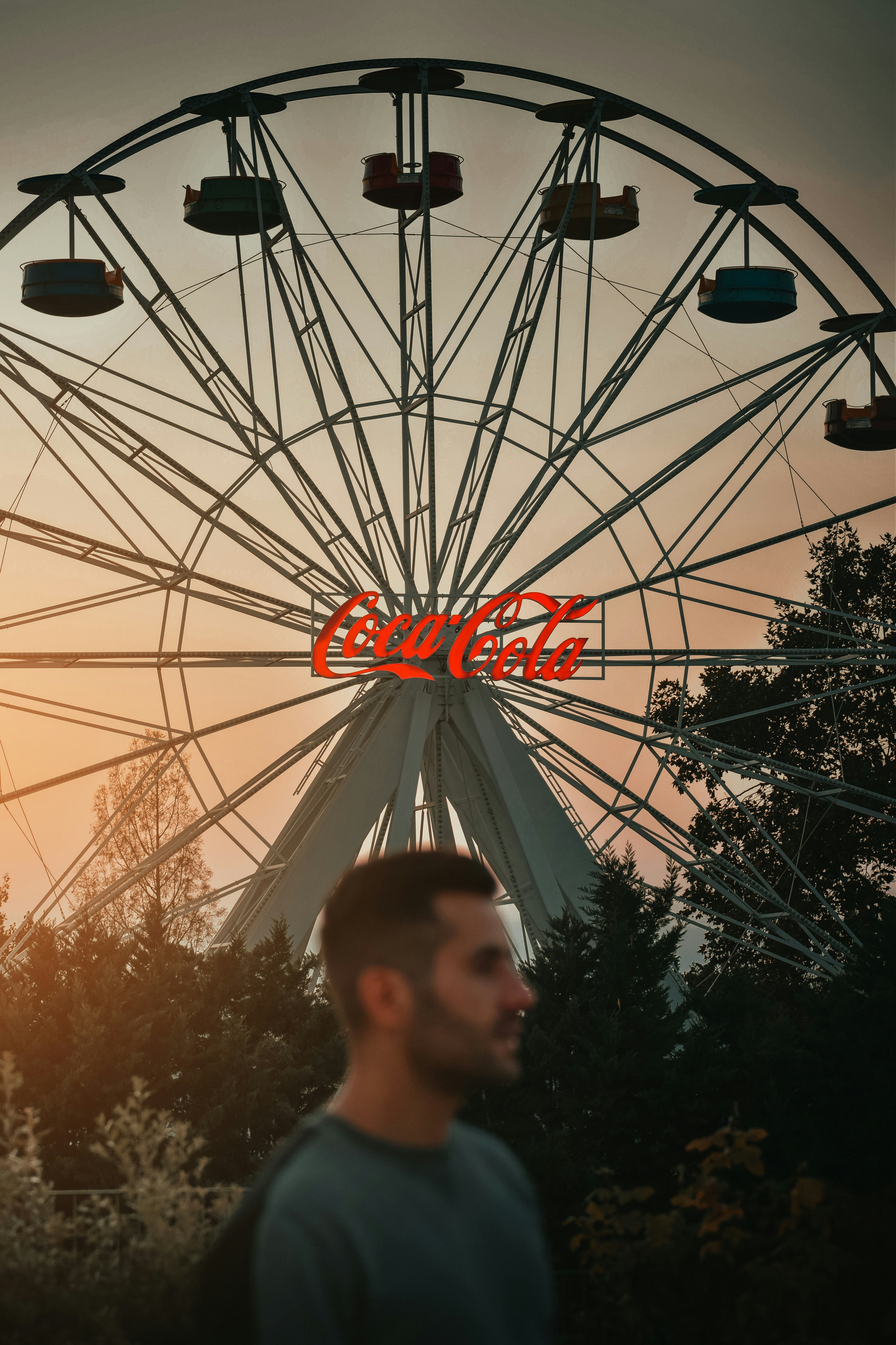 Un hombre parado frente a una noria