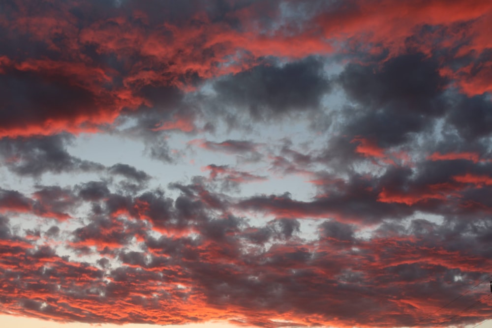 a red sky with clouds and a traffic light