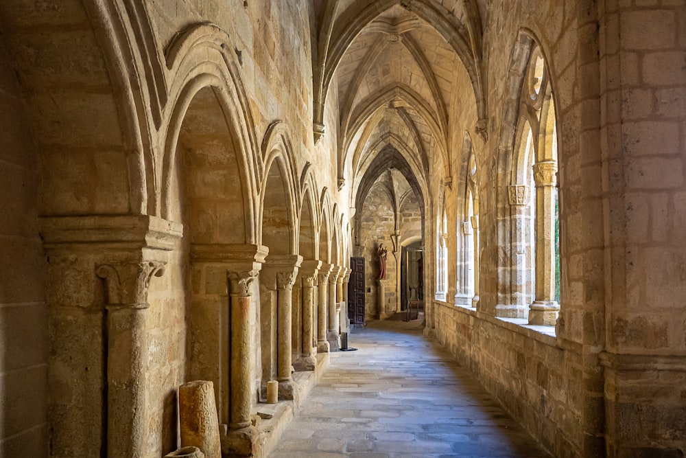 um longo corredor com arcos e paredes de pedra