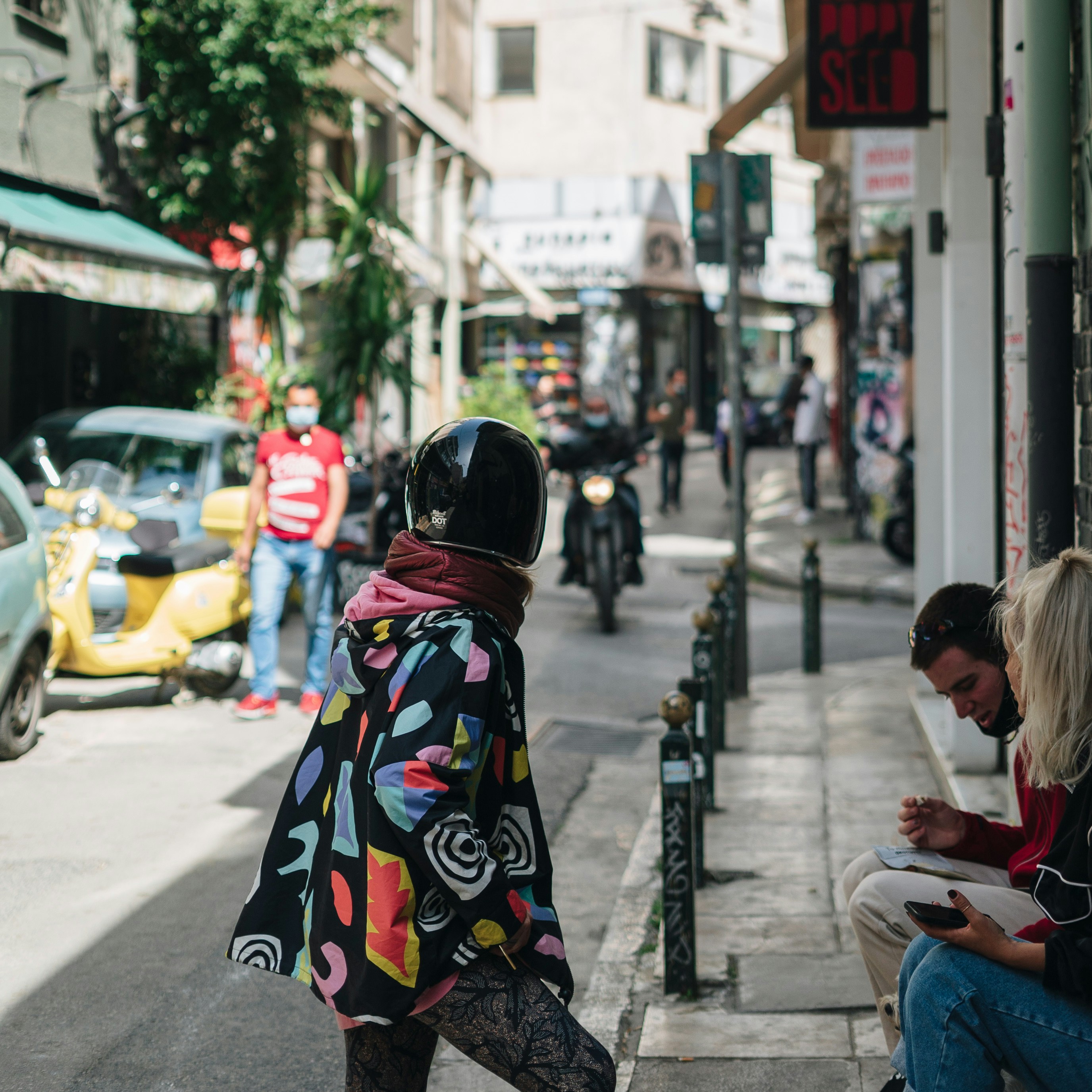 a woman sitting on a bench on a city street