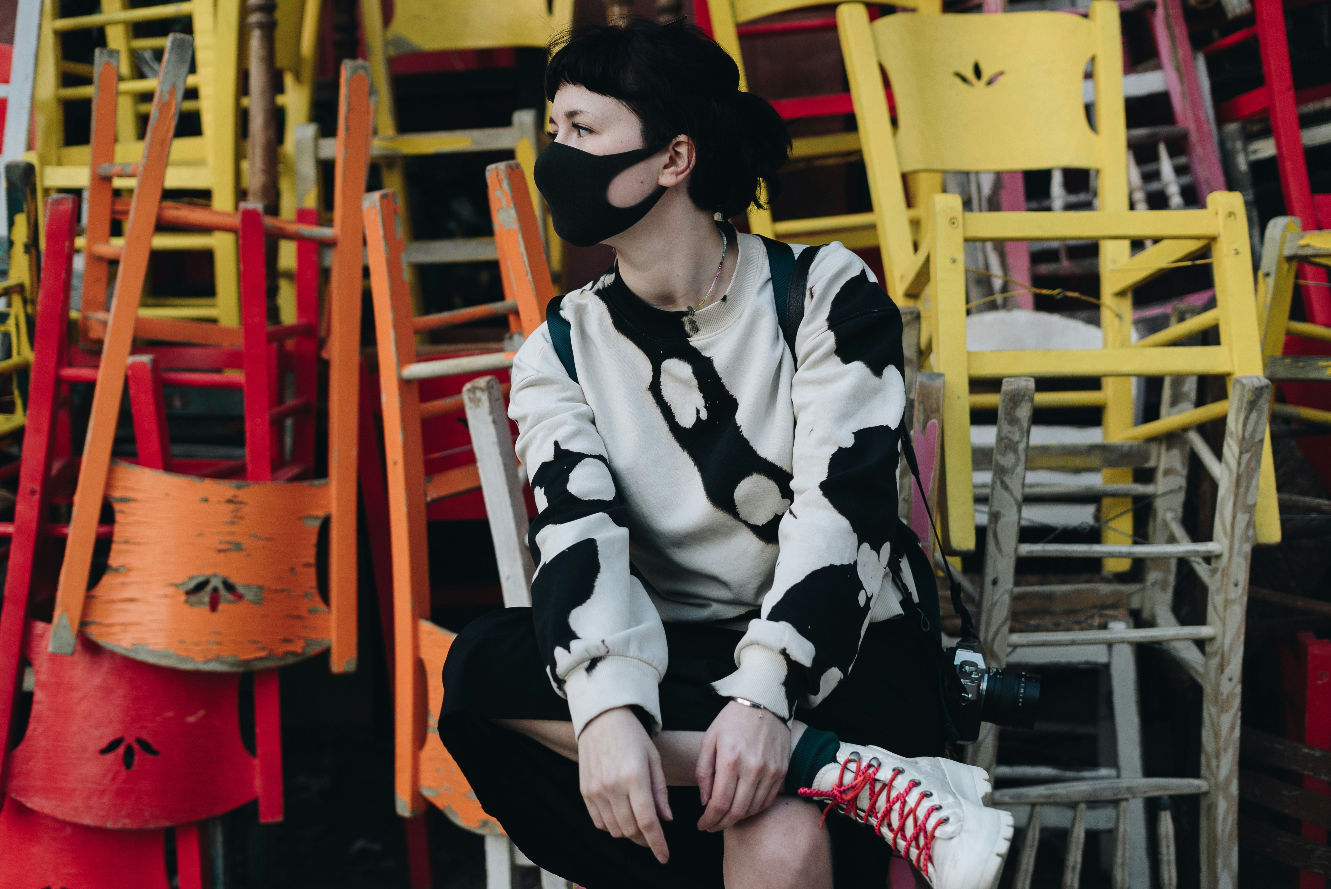 a woman sitting on a chair wearing a face mask