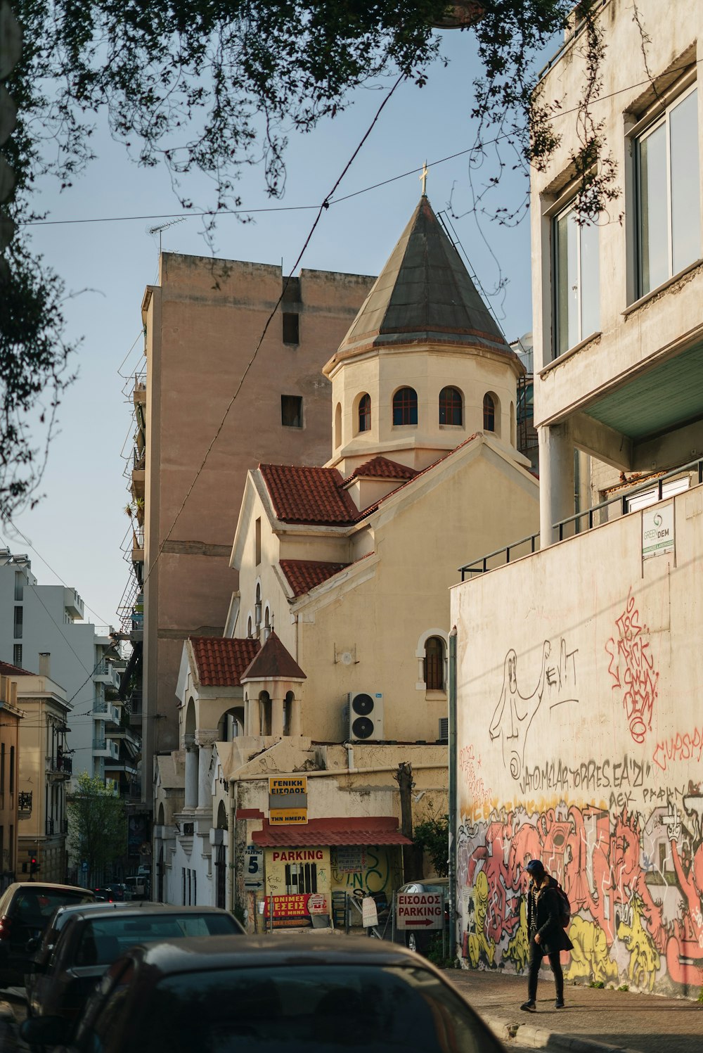 a man walking down a street next to tall buildings