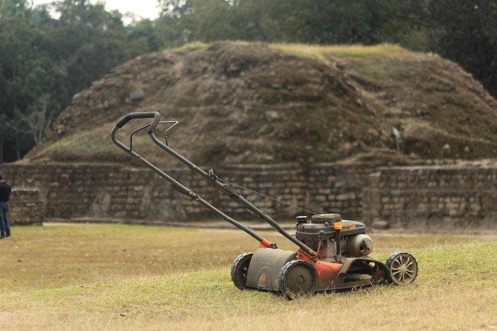 a lawn mower sitting on top of a dry grass field