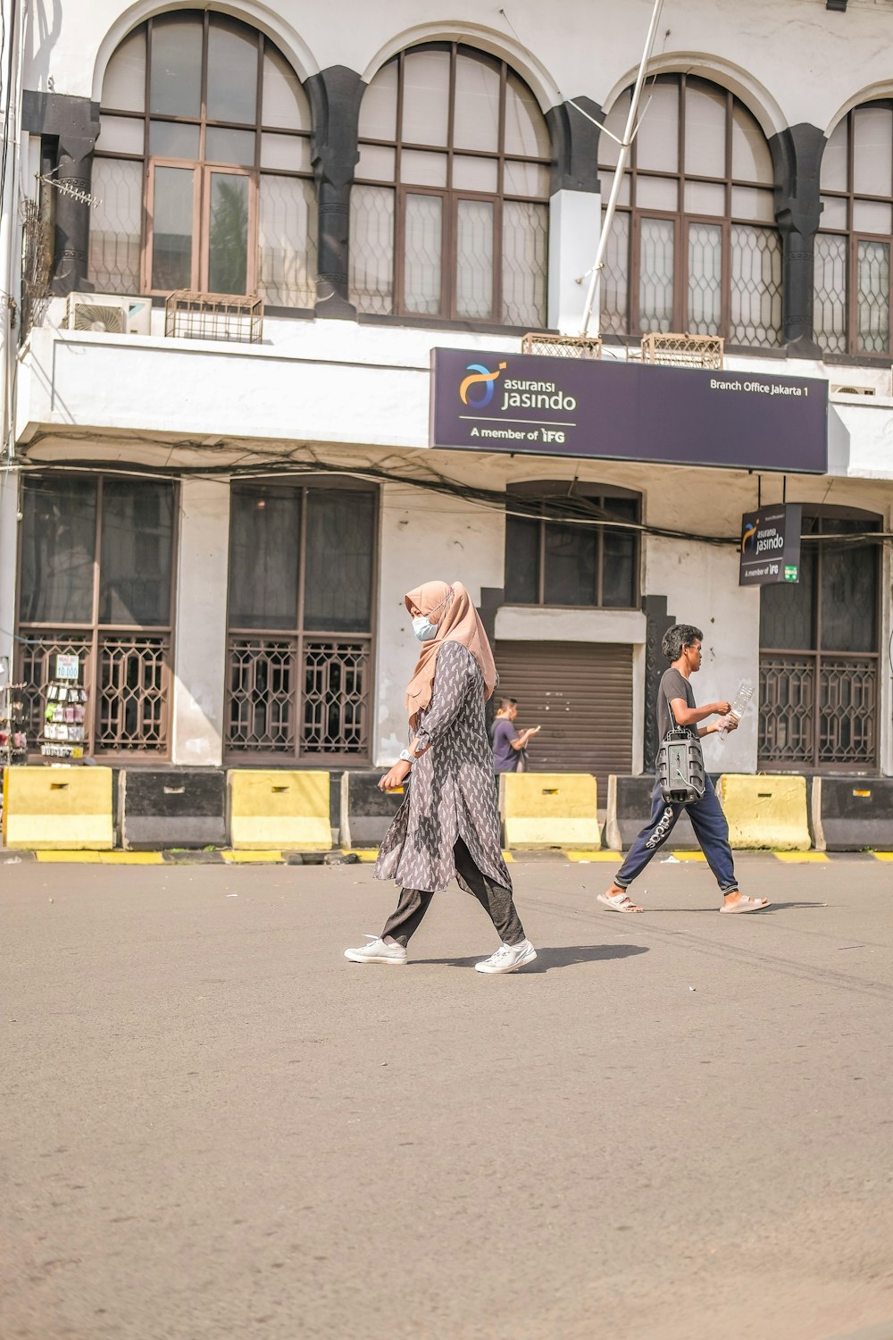 a group of people walking across a street