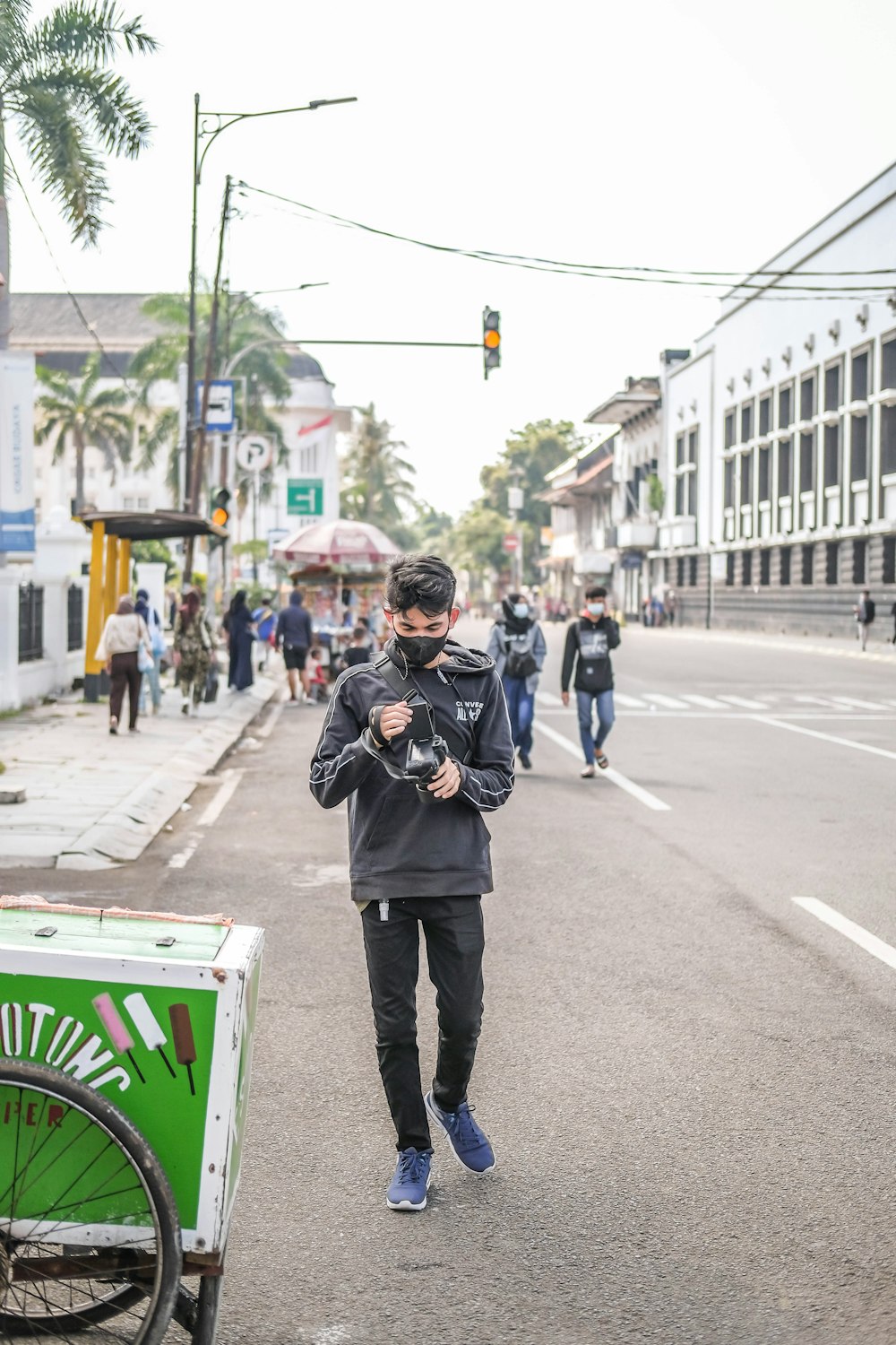 a man walking down a street next to a bike