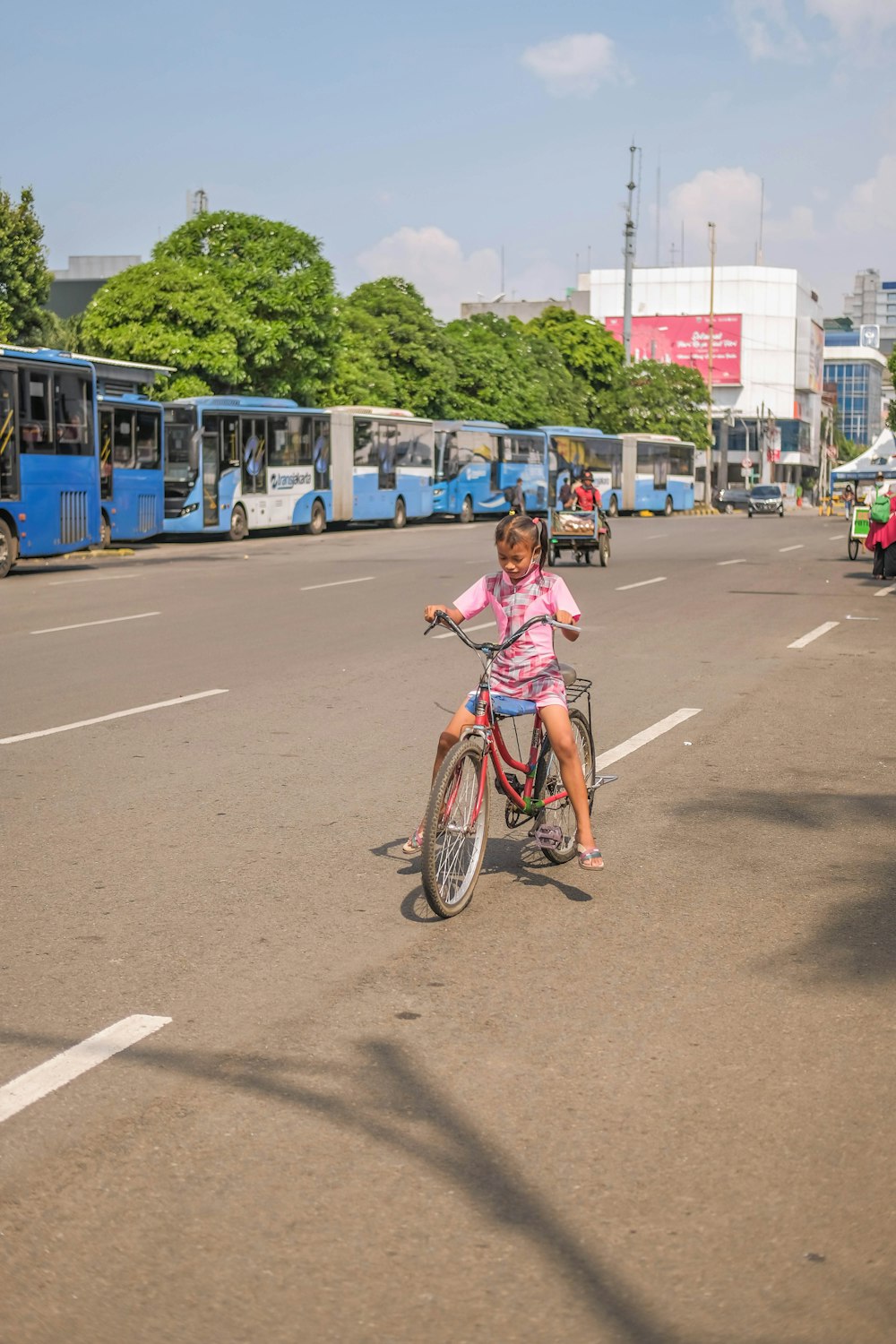 a little girl riding a bike down a street