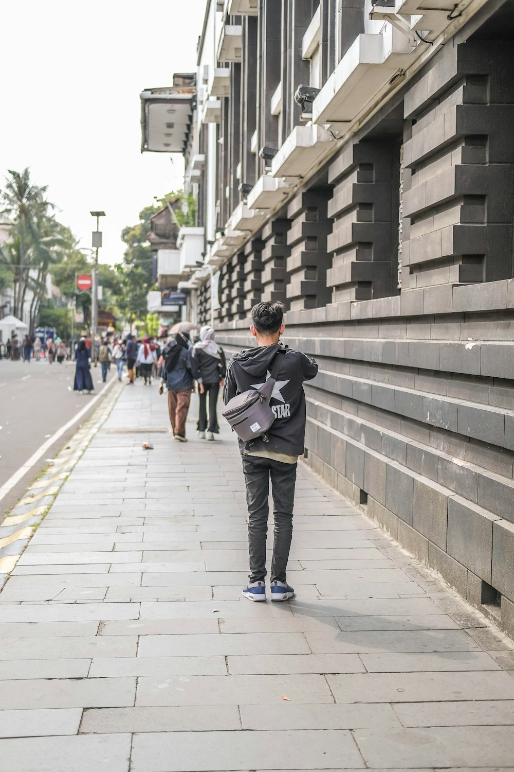 a person walking down a sidewalk next to a building