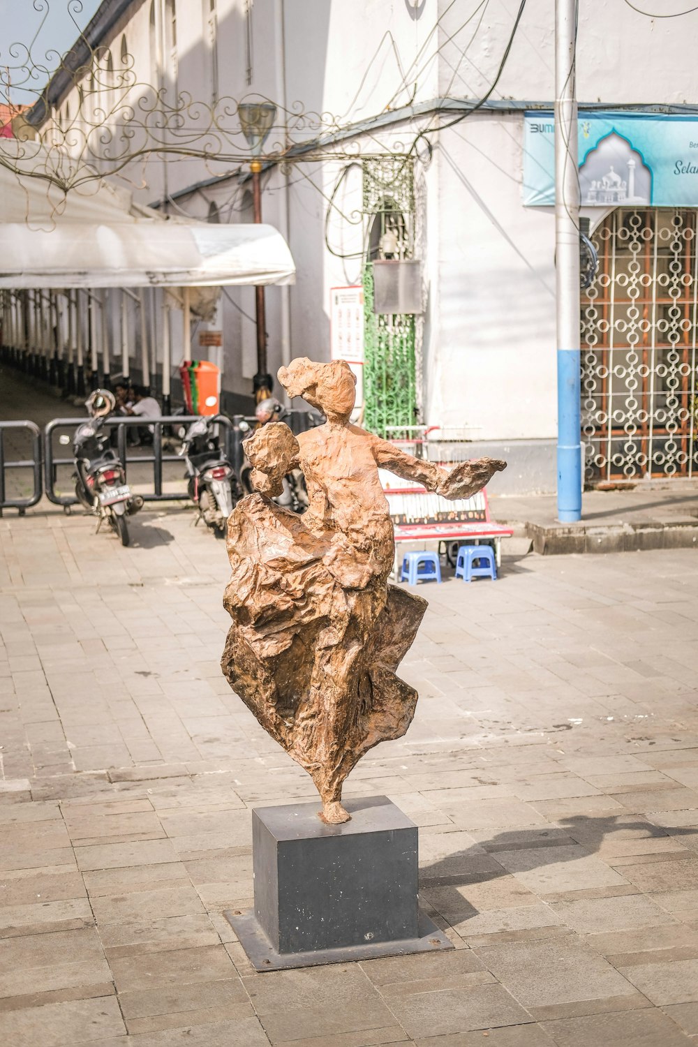 a statue of a woman sitting on top of a wooden block