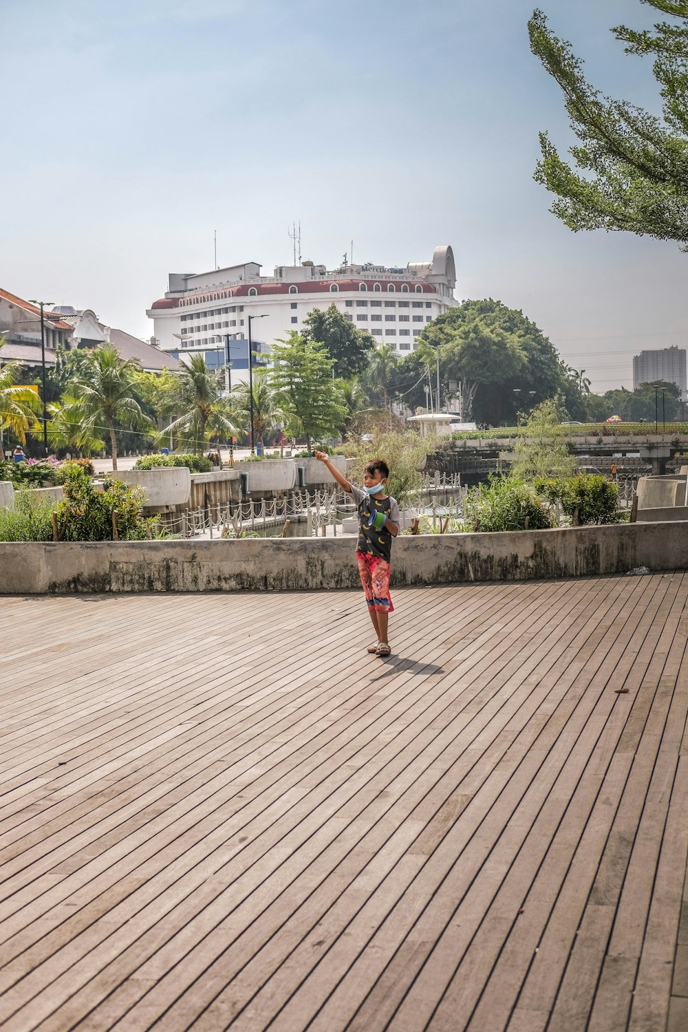 a person standing on a wooden deck with a building in the background