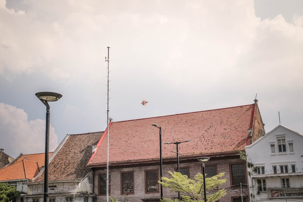 a building with a red roof and a street light