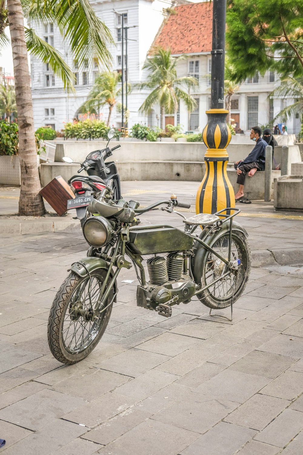 a motorcycle parked next to a yellow and black fire hydrant