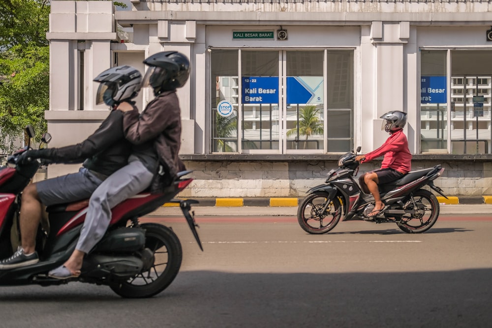 a couple of people riding on the back of motorcycles